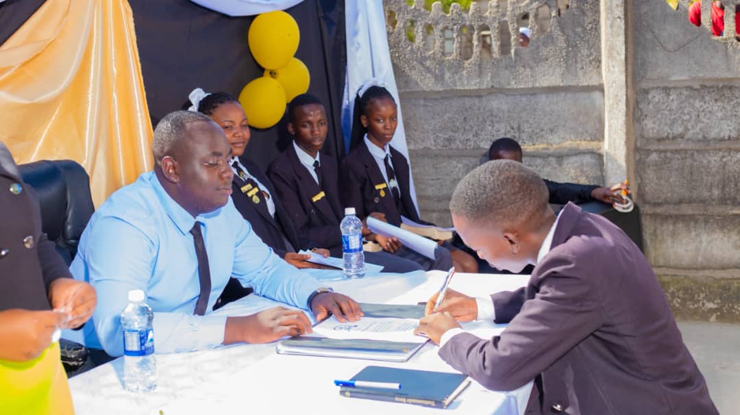 Staff and prefects signing the prefect register during the induction ceremony